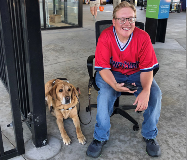 photo of Andrew Crane & his guide dog Vaughn at work scanning Wind Surge tickets at Riverfront Stadium