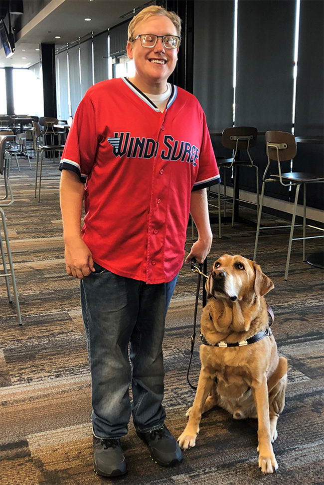 Andrew Crane and his guide dog Vaughn at work inside Wichita’s Riverfront Stadium